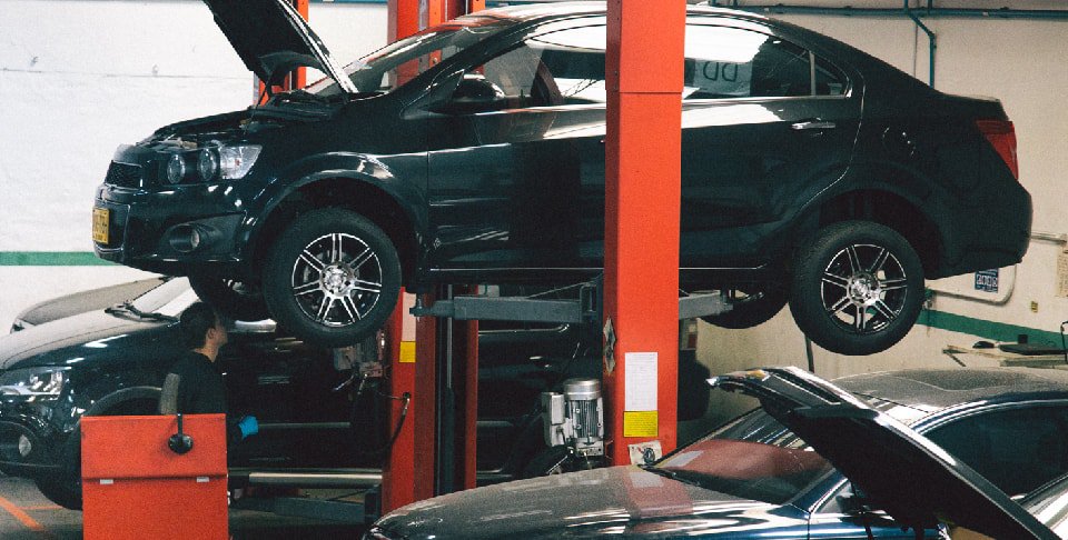 Carro en un taller sobre una plataforma elevadora